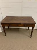 A regency mahogany writing table on turned tapering legs (H77cm W120cm D60cm)