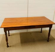 A dining table on turned legs with central drawer