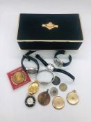 A selection of five watches, some coins and a locket in a musical jewellery box