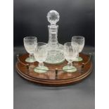 A Cut Glass Decanter set with four glasses on a Mahogany Stand.