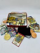 A Variety of collectable coins and medallions in a biscuit tin