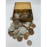 A small metal tin contains a variety of coins, various countries, denominations etc