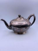 A white metal tea pot with acorn finial on lid (repair to base)