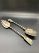 A pair of large white metal serving spoons