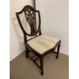 A shield back chair with fleur-de-lis carved to back and square tapering to legs