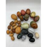 A selection of wooden and onyx eggs and hand painted Russia eggs