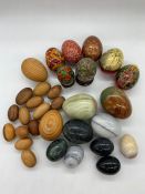 A selection of wooden and onyx eggs and hand painted Russia eggs