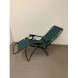 A reclining garden chair with green seat covering