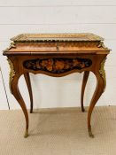 A gilt metal mounted display case on legs, veneered and brass bound with pierced gallery over a