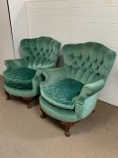 Pair of upholstered armchairs curved button back of a mid century design