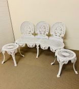 A wrought iron garden bench and two stools/table