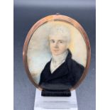 An Oval Framed Miniature of a Gentleman with a framed lock of hair to rear of frame.