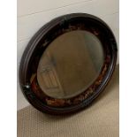 An oval mirror with hand painted frame depicting on oriental scene
