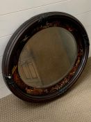 An oval mirror with hand painted frame depicting on oriental scene