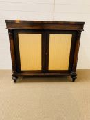 A Rosewood Chiffonier with a pair of doors to front with silk panels, flanked by turned columns