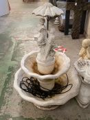 Two tier water feature fountain with a couple under an umbrella to top