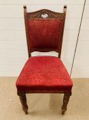 A dining chair on turned legs and red upholstered seat and back