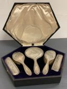 A Boxed set of silver backed vanity set to include a mirror and four brushes.