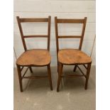 A pair of wooden kitchen chairs