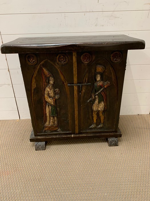 An oak two door cabinet with carved medieval style figures (H72cm W75cm D36cm)