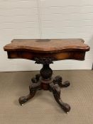 A walnut serpentine card table on a lobed baluster column and four down swept legs AF (H76cm W90cm