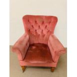 A pink velvet button back armchair