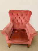 A pink velvet button back armchair