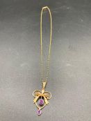 An Untested gold and amethyst pendant on a rolled gold chain.