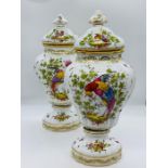 A pair of porcelain vases with lids, painted with exotics birds and scattered springs, stamped