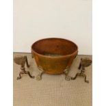 A large coal bin in copper with lion handles and claw feet and a pair of copper fire dogs