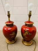 A pair of Oriental red table lamps with scenes of golden dragons