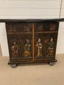 An oak two door cabinet with carved medieval style figure and two dummy drawers (AF) (H78cm W100cm