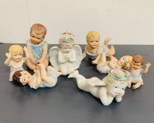 Eight china cherubs of various sizes