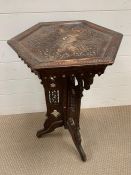 A plant stand or occasional table with decorative inlay.