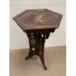 A plant stand or occasional table with decorative inlay.