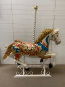 A carousel horse decorated with gilt flowers (H160cm W146cm D50cm)