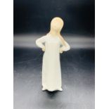 A Lladro figure of a girl with hands on hips