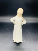 A Lladro figure of a girl with hands on hips