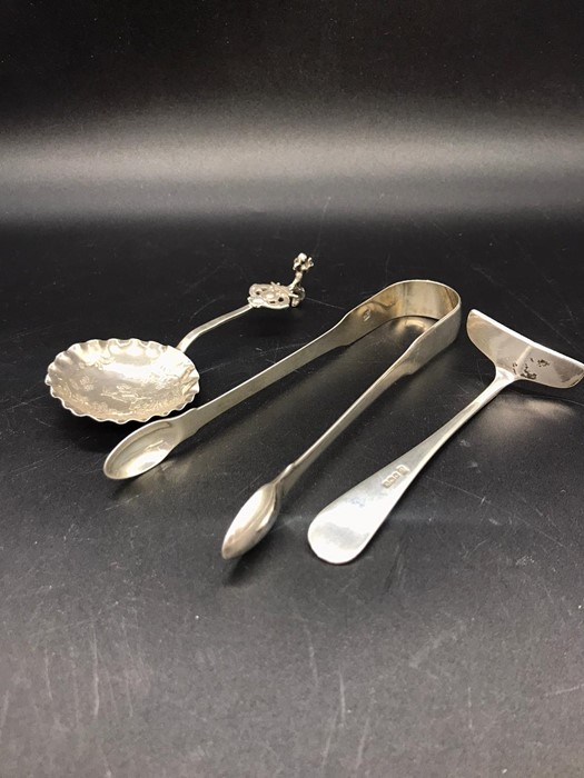 Three silver hallmarked items to include sugar nips, children's food pusher and a spoon. - Image 2 of 4