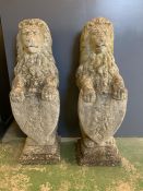 A Pair of weathered Majestic stone lions with Heraldic Shields