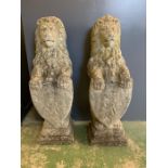 A Pair of weathered Majestic stone lions with Heraldic Shields