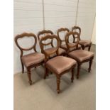 Six balloon back dining chairs on turned legs and upholstered seats