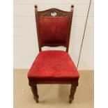 A dining chair on turned legs and red upholstered seat and back