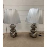 A pair of contemporary lights with silver shades