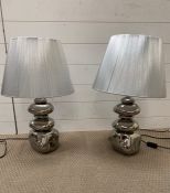 A pair of contemporary lights with silver shades