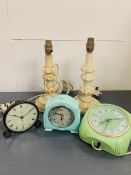 Three Bakelite clocks and a pair of white table lamps.