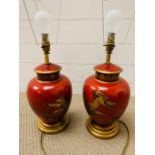 A pair of Oriental red table lamps with scenes of golden dragons
