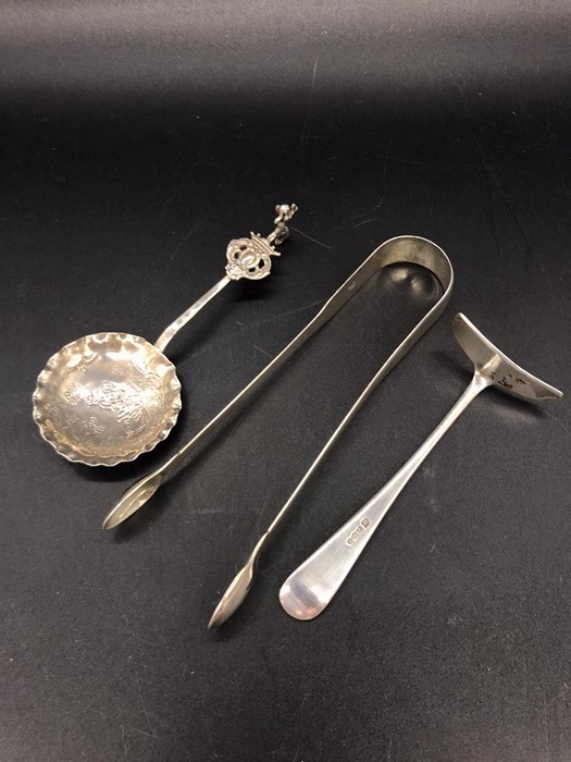 Three silver hallmarked items to include sugar nips, children's food pusher and a spoon. - Image 3 of 4