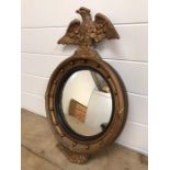 A gilt wood convex mirror with ball decoration and carved giltwood eagle