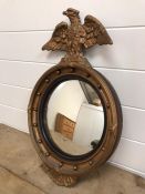 A gilt wood convex mirror with ball decoration and carved giltwood eagle